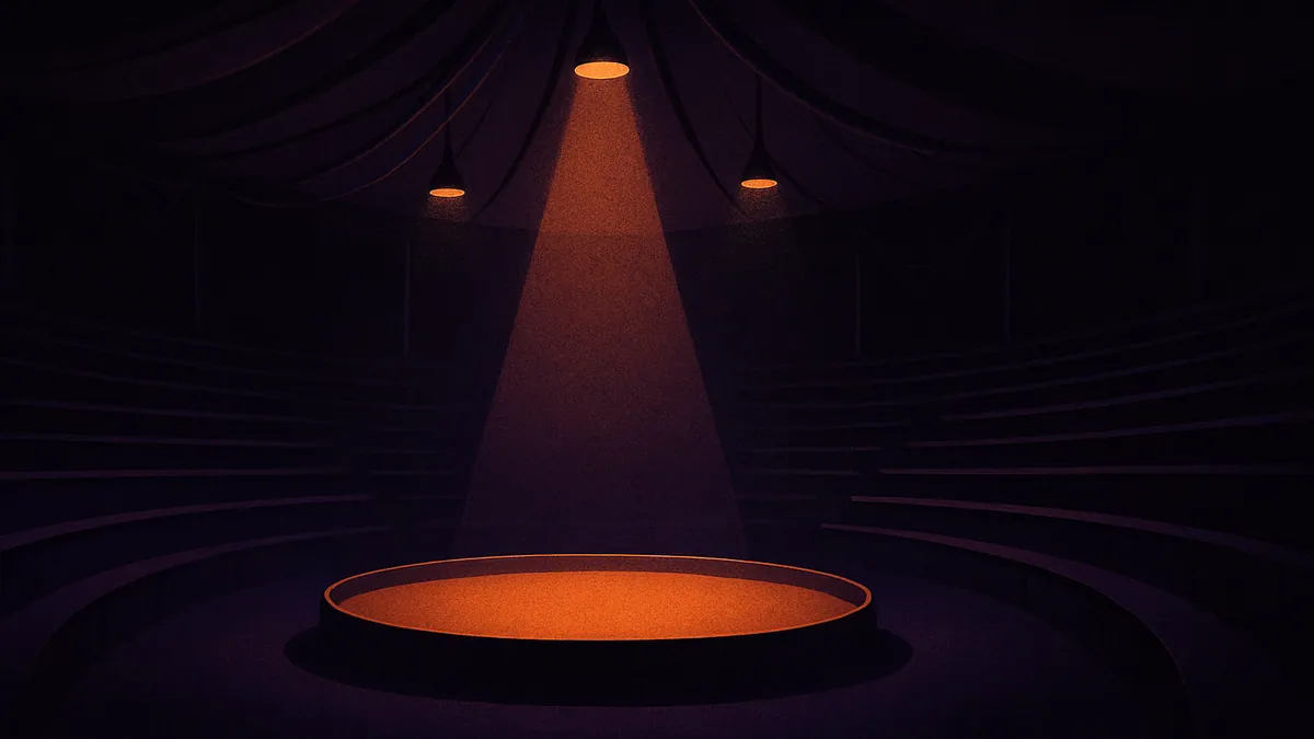 Vista interior de una carpa donde sentarse en el circo con las gradas y la pista circular iluminada por focos cálidos.